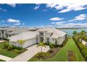 Stunning exterior elevation with manicured lawn, beautiful landscaping, and a large three-car garage at 508 Blue Shell Loop, Sarasota, FL 34240