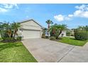 Well-maintained home with a two-car garage, lush landscaping, and a concrete driveway on a sunny day at 5238 Aqua Breeze Dr, Bradenton, FL 34208
