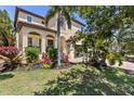Charming home featuring a covered front porch, well-manicured lawn and colorful landscaping at 5503 Title Row Dr, Bradenton, FL 34210