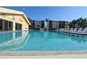 Community pool surrounded by lounge chairs and beautiful landscaping at 625 30Th W Ave # G210, Bradenton, FL 34205