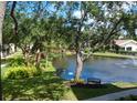 Scenic view of a community pond with a fountain, benches, and lush greenery at 625 30Th W Ave # G210, Bradenton, FL 34205
