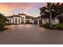 Exterior dusk shot of a well-maintained home showcasing a brick driveway and lush landscaping at 7218 Teal Creek Gln, Lakewood Ranch, FL 34202