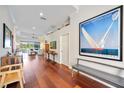 Hallway with hardwood floors, white walls, art and a bench at 7231 Brambury Ct, Sarasota, FL 34238