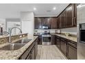 Modern kitchen with dark wood cabinets, stainless steel appliances, and granite countertops at 7418 61St E St, Palmetto, FL 34221