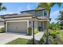 Two-story home boasting a two-car garage and nicely landscaped front yard featuring a walkway to the front door at 7743 Nightfall Ter, Sarasota, FL 34241