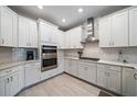 A well-equipped kitchen with stainless steel appliances, white subway tile, and a modern range hood at 7743 Nightfall Ter, Sarasota, FL 34241