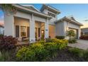 Inviting single-story home featuring a covered porch and lush landscaping at 8195 Redonda Loop, Lakewood Ranch, FL 34202
