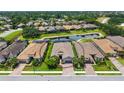 Aerial view of house with terracotta roof near a pond, featuring well-manicured lawns and mature trees at 8713 Mangilli Rd, Sarasota, FL 34238
