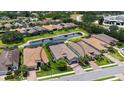 Aerial view of home with tiled roof, and a pond nearby, in a neighborhood with tree coverage and street access at 8713 Mangilli Rd, Sarasota, FL 34238