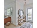 Inviting foyer features tile flooring, decorative mirror, console table, and natural light from the front door at 10108 Kingfisher E Rd, Bradenton, FL 34209