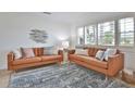 Bright living room showcasing two leather sofas, stylish rug, plantation shutters, and decorative fish art at 10108 Kingfisher E Rd, Bradenton, FL 34209