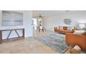 Open-concept living room with tile floors, leather furniture, and tasteful décor, leading into dining area at 10108 Kingfisher E Rd, Bradenton, FL 34209