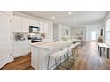 Bright kitchen with white cabinets, marble countertops, stainless steel appliances, and a large center island with barstool seating at 10714 Hidden Banks Gln, Parrish, FL 34219