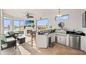 Outdoor kitchen features granite countertops, stainless steel appliances, bar seating, and a stunning backyard view at 10819 Wicker Park Pl, Palmetto, FL 34221