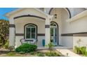 Inviting front porch with seating and a charming blue front door and beautifully landscaped yard at 11116 Sanctuary Dr, Bradenton, FL 34209