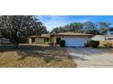 Charming single story home with two-car garage and mature trees shading the front yard at 1218 Carmella Ln, Sarasota, FL 34243