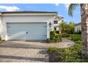 A well-kept home featuring a light blue two car garage door, clean landscaping, and a brick paver driveway and walkway at 12706 Cobalt Ter, Bradenton, FL 34211