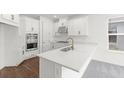Bright and airy kitchen with white cabinets, stainless steel appliances, and a large island with a modern faucet at 15001 Shady Palms Ln, Nokomis, FL 34275