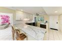 Bright kitchen features granite counters, white cabinetry, and stainless steel appliances at 1617 Bayhouse Ct # 121, Sarasota, FL 34231