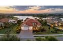 Beautiful aerial view of the home by the lake with lush landscaping and a tile roof at 16309 Castle Park Ter, Lakewood Ranch, FL 34202