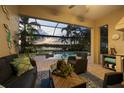 Cozy screened-in patio featuring comfortable seating, a pool, and scenic water views at 16309 Castle Park Ter, Lakewood Ranch, FL 34202