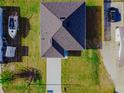 Aerial shot of a home with a dark roof, long driveway, and surrounding green lawn and foliage at 18182 Steele Ave, Port Charlotte, FL 33948