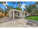 Beautiful home featuring an expansive driveway, carport, manicured lawn, and freshly painted white exterior at 2535 Floyd St, Sarasota, FL 34239
