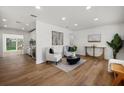 Bright living room featuring modern decor, hard wood floors, white walls, with a glimpse into the kitchen at 2535 Floyd St, Sarasota, FL 34239