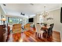 Open-concept living room and dining area featuring hardwood floors and backyard views at 3103 77Th E Dr, Sarasota, FL 34243