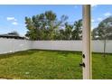 Grassy backyard, enclosed by a white privacy fence, is accessed by a glass door at 3111 W Nassau St, Tampa, FL 33607
