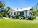Charming home with a metal roof, manicured lawn, and lush landscaping at 324 Julia Pl, Sarasota, FL 34236