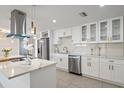 Bright and modern kitchen featuring white cabinets, stainless steel appliances, and stylish pendant lighting at 3370 Harbor Lake Dr, Largo, FL 33770