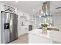 Modern kitchen featuring white cabinetry, stainless steel appliances, a wine rack, and quartz countertops at 3370 Harbor Lake Dr, Largo, FL 33770