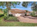 Lovely home featuring a brick driveway, a coral toned exterior, and mature landscaping at 4730 Old Farm Rd, Sarasota, FL 34233