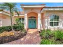 Welcoming front entrance with a brick pathway, colorful door, and lush landscaping at 4730 Old Farm Rd, Sarasota, FL 34233