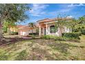 Inviting home with lush landscaping, a coral-toned exterior, tile roof, and a brick driveway at 4730 Old Farm Rd, Sarasota, FL 34233