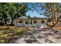 Charming single-story home featuring a classic white facade surrounded by mature trees and a driveway at 4918 Lahaina Dr, Sarasota, FL 34232