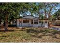 Charming single-story home featuring a classic white facade surrounded by mature trees at 4918 Lahaina Dr, Sarasota, FL 34232
