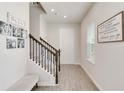 Bright foyer with light wood-look flooring, staircase, and a cozy bench, creating a welcoming entrance at 5514 Spanish Moss Cv, Bradenton, FL 34203