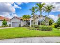 Well-maintained home with a lush front lawn and mature palm trees at 5923 Snowy Egret Dr, Sarasota, FL 34238