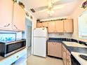 This is the kitchen with upper decorations, appliances, and an adjacent doorway at 5951 Todd St # D37, Bradenton, FL 34207