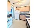 The kitchen has light cabinetry, white appliances, and a ceiling fan above with an adjacent doorway at 5951 Todd St # D37, Bradenton, FL 34207