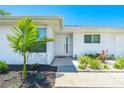 Inviting home entrance with a white front door, well-kept landscaping and a clear view of the house number at 6698 Acmar Ct, North Port, FL 34287