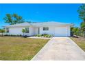 Attractive home featuring a manicured front lawn, an attached garage and an easily accessible concrete driveway at 6698 Acmar Ct, North Port, FL 34287