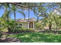 Beautiful home exterior featuring a well-manicured lawn and lush tropical landscaping at 6924 Cumberland Ter, University Park, FL 34201