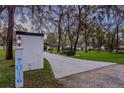 Long driveway leading to a charming home nestled among mature trees and manicured landscaping at 7016 Dusty Rd, Riverview, FL 33569