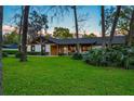 Charming single-story home with well-manicured lawn and stylish exterior accents under a twilight sky at 7016 Dusty Rd, Riverview, FL 33569