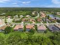 Aerial view of single-story home with screened-in pool in a lushly landscaped neighborhood at 7659 Trillium Blvd, Sarasota, FL 34241