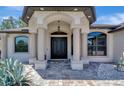 Close-up of the home's entrance featuring a double door, stone walkway, and elegant pillars at 8123 Wawana Rd, North Port, FL 34287