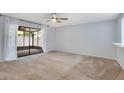 Spacious bedroom with neutral carpet, ceiling fan, and large sliding doors leading to screened patio at 928 Sunridge Dr # F2, Sarasota, FL 34234